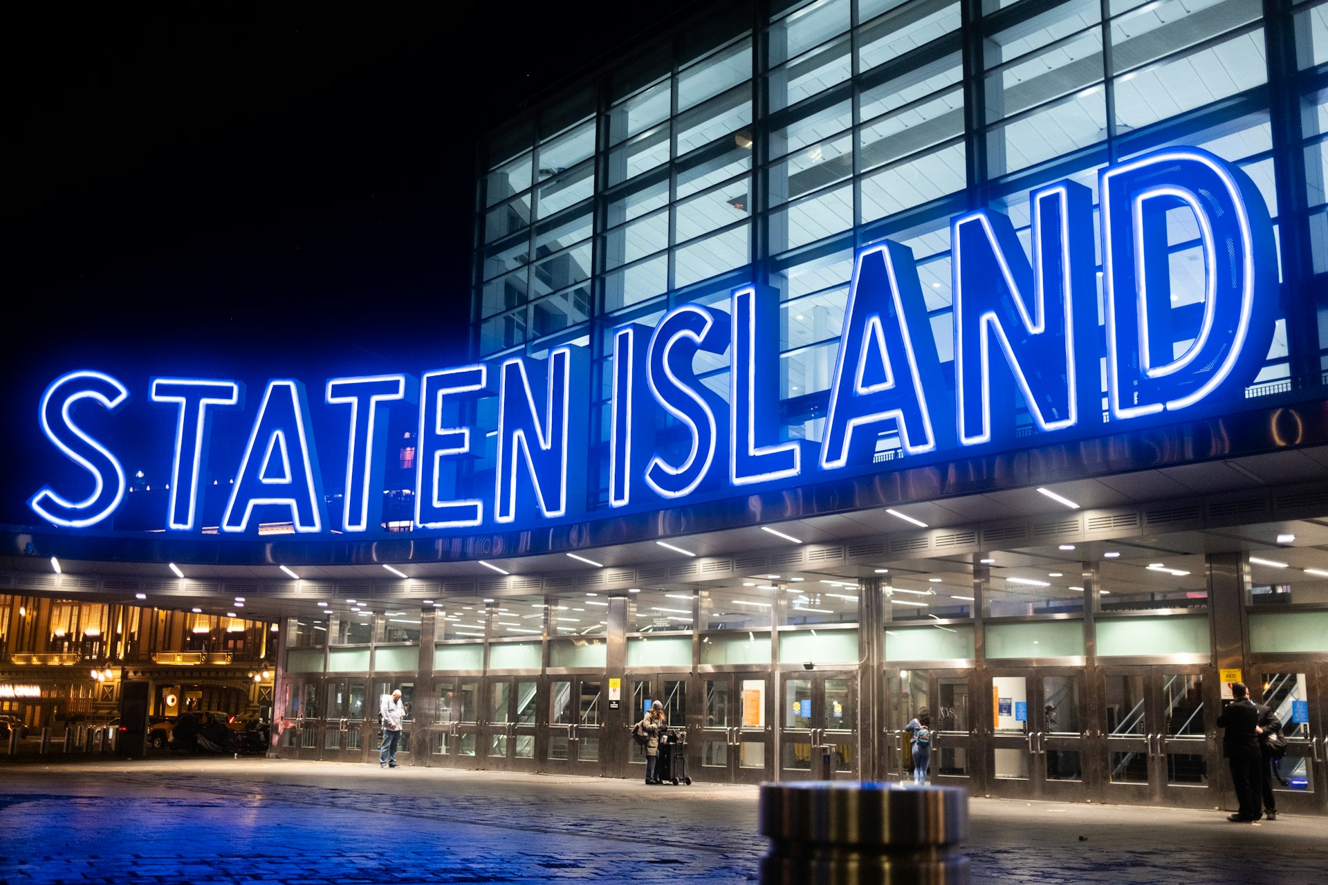 Staten Island Ferry Terminal at Night | Pinpoint Illuminated Staten Island Ferry sign at Whitehall Terminal in Lower Manhattan at night.